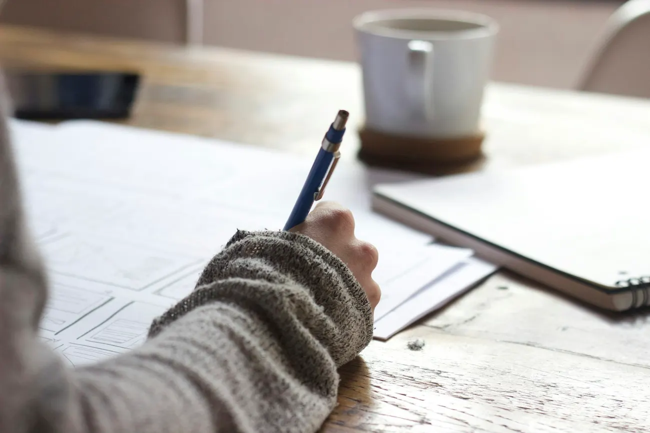Pessoa fazendo anotações de estudo em um caderno